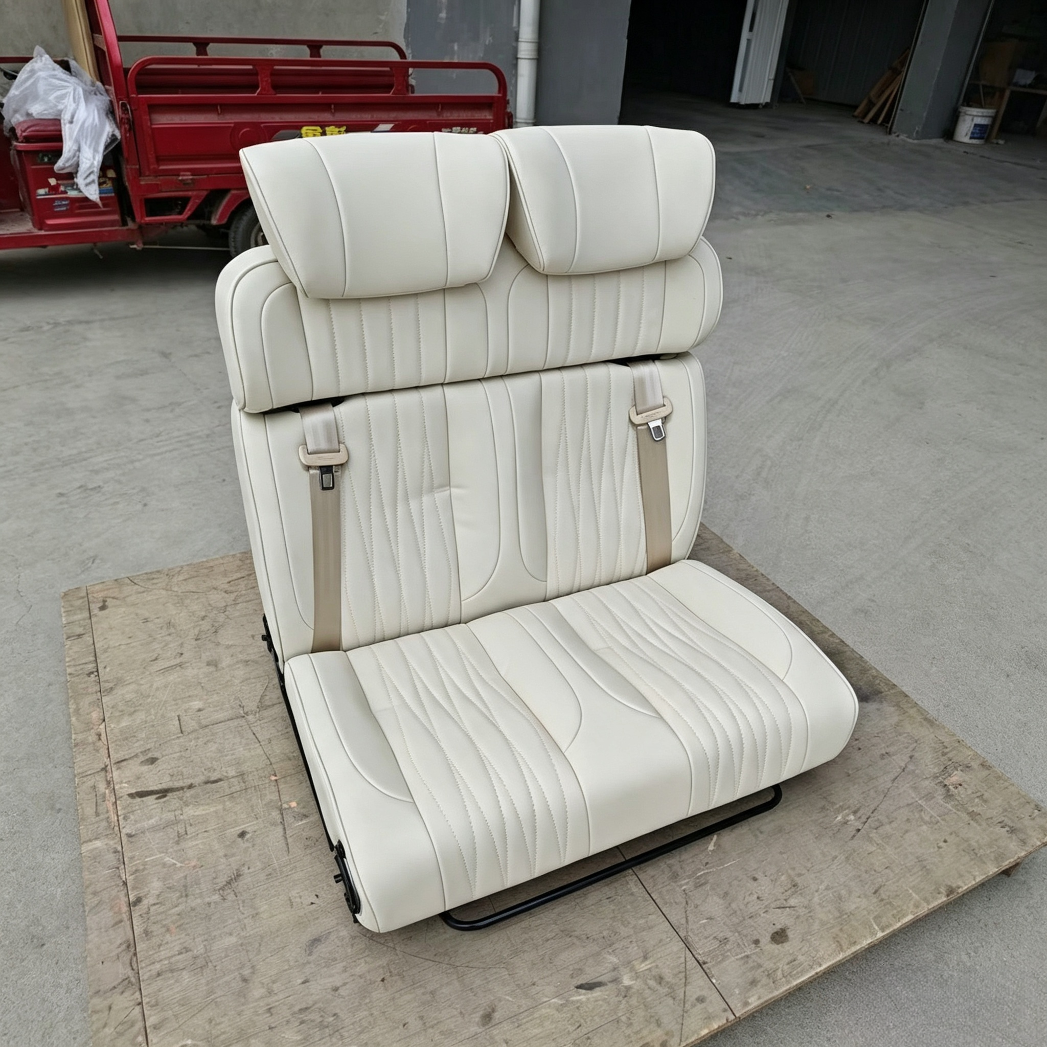 Beige leather reclining camper van seat bed showing backrest vertical stitching