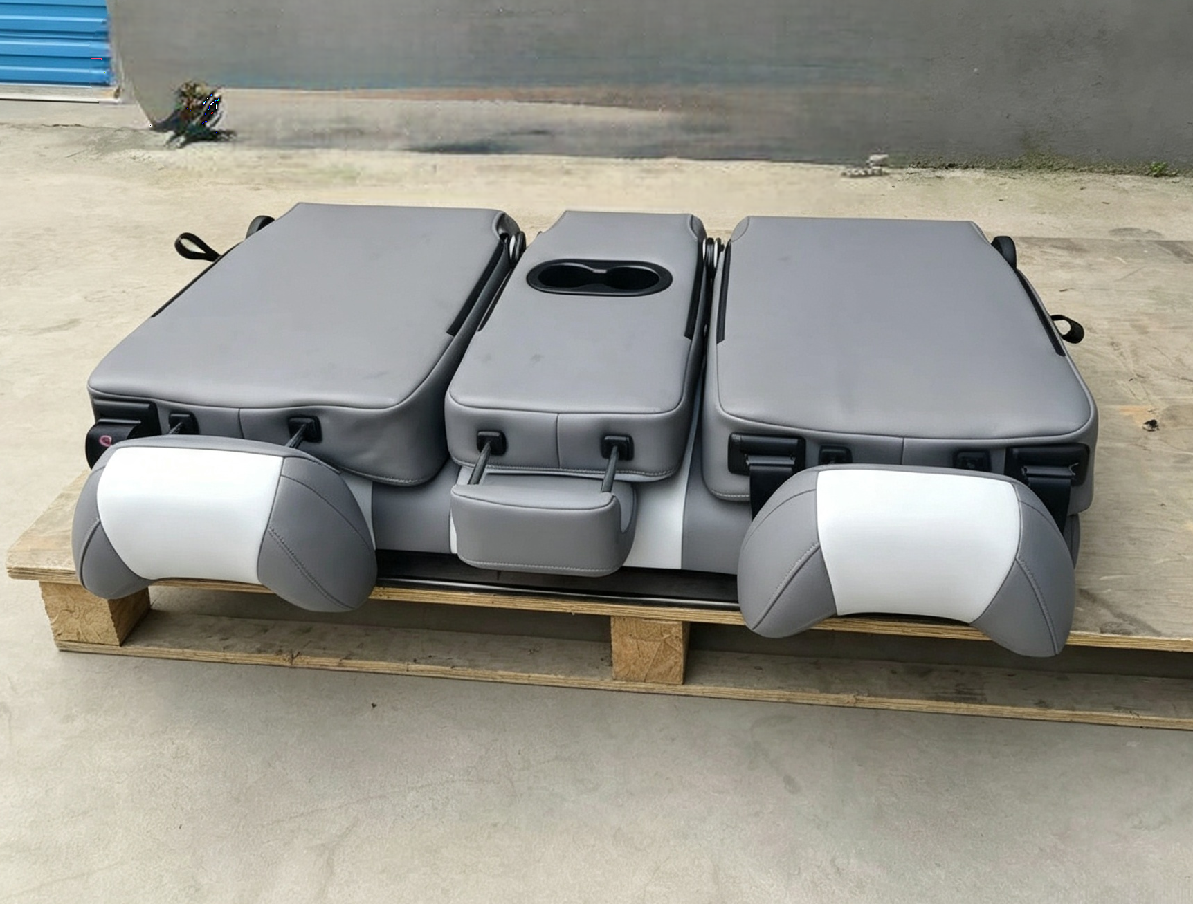 Two-tone gray and white van seat bed completely folded flat into a sleeping bed